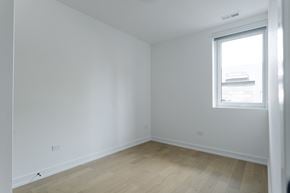 Chicago apartment for rent - A room with a window and wooden flooring.