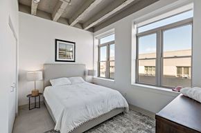 Hammond apartment for rent - A bedroom with a large bed and a window overlooking a building.