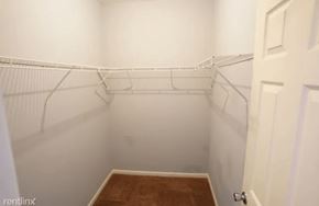 Chicago apartment for rent - a white walk in closet with white shelves and a door