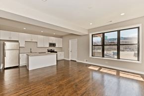Chicago apartment for rent - A spacious kitchen with white appliances and cabinets.