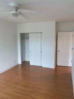 Chicago apartment for rent - an empty living room with wood floors and a ceiling fan