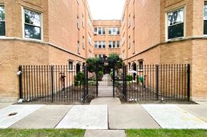 Chicago apartment for rent - a courtyard between two brick buildings with a wrought iron gate