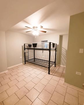 Chicago apartment for rent - A room with a ceiling fan and a shelf.