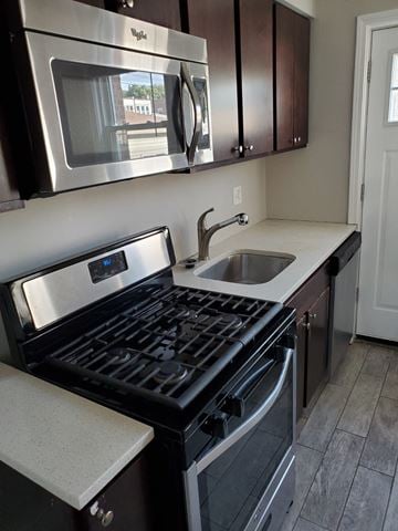 Chicago apartment for rent - A modern kitchen with a stove top oven and microwave above it.