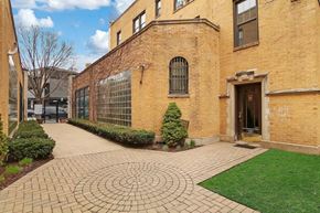 Chicago apartment for rent - the exterior of a brick building with a walkway and grass