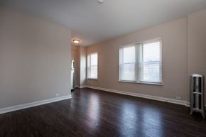 Chicago apartment for rent - an empty living room with wood floors and a window