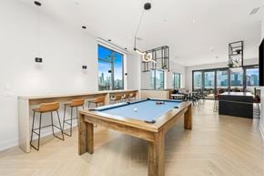 Chicago apartment for rent - A billiard table is in the middle of a room with a bar and a pool table.