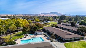 Walnut Creek apartment for rent - Aerial view of a pool with mountains in the background at The Grove at Walnut Creek Apartments in Walnut Creek, CA.