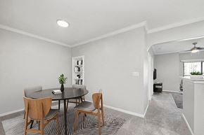 Lewisville apartment for rent - Model Dining Room with Carpet and View of Living Room at Hidden Creek Apartments located in Lewisville, TX.