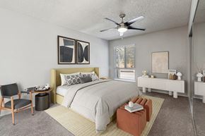 El Cajon apartment for rent - 1-Bedroom Apartments in El Cajon, CA - Colonnade at Fletcher Hills - Spacious Bedroom with Ceiling Fan and Carpeting, Upholstered Headboard, Neutral Bedding, Window Blinds, and Mirrored Closet Doors.