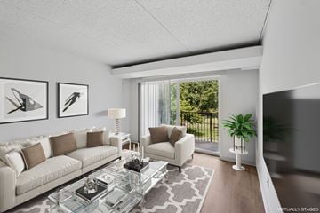 Alexandria apartment for rent - A modern living room with a glass coffee table and a large window.