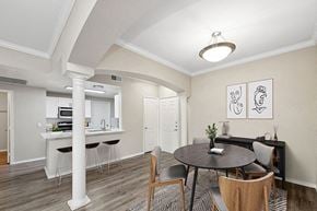 Dallas apartment for rent - Model Dining Room with Wood-Style Flooring and View of Kitchen at Allure North Dallas Apartments located in Dallas, TX.