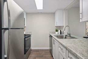 Salt Lake City apartment for rent - Model Kitchen with White Cabinets and Wood-Style Flooring at Overlook Point Apartments in Salt Lake City, UT.