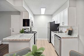 Lakewood apartment for rent - Model Kitchen with White Cabinets and Wood-Style Flooring at Waterfront Apartments in Lakewood, CO.