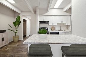 Glendale apartment for rent - Model Kitchen with White Cabinets and Wood-Style Flooring at Esprit at Cherry Creek Apartments in Glendale, CO.