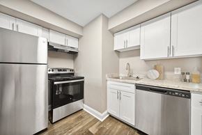 Marlborough apartment for rent - Model Kitchen with White Cabinets and Wood-Style Flooring at Heights at Marlborough Apartments located in Marlborough, MA.
