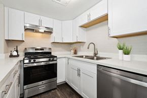 Phoenix apartment for rent - Two-Bedroom Affordable Apartments in Camelback East Village, AZ - Arcadia on 49th - A Kitchen With Shaker Cabinets, Stainless Steel Gas Range And Dishwasher, Quartz Counters, And A Double Sink.