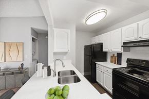 Jacksonville apartment for rent - Model Kitchen with White Cabinets and Wood-Style Flooring at Vue at Baymeadows Apartments in Jacksonville, FL.