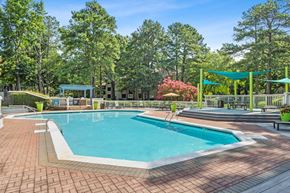 Marietta apartment for rent - Pet-Friendly Apartments in Marietta, GA - Element 41 - A Swimming Pool With Brick Paver Deck, Shade Sails, Lounge Seating, And Lush Trees Under A Clear Blue Sky.