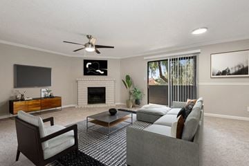 Phoenix apartment for rent - Model apartment living room with a couch and a chair and a ceiling fan
