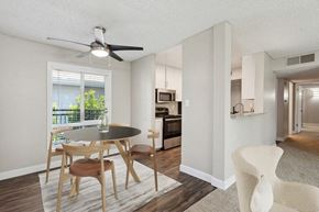 Sacramento apartment for rent - Model dining area with a table and chairs and a kitchen in the background