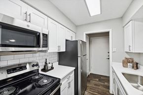Dallas apartment for rent - 1 Bedroom Apartments in Far North Dallas, TX - Bridges at Deer Run - Updated Galley Kitchen With White Cabinets, Subway Tile Backsplash, Stainless Steel Appliances, And Single Bowl Sink