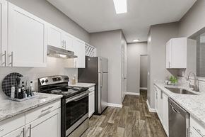 Marietta apartment for rent - 1-Bedroom Luxury Apartments in Marietta, GA - Parkside at Town Center - Bright White Kitchen With Granite Countertops, Stainless Steel Range, Subway Tile Backsplash, And Wood Style Flooring.