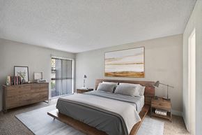 Anaheim apartment for rent - Model Bedroom with Carpet and Patio Accessibility at Madison Park Apartments located in Anaheim, CA.