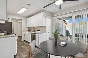 Avondale apartment for rent - Model Dining Room with Wood-Style Flooring, View of Kitchen and Patio Accessibility at Peaks on 4th Apartments in Avondale, AZ.