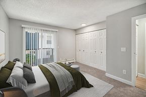 Lakewood apartment for rent - Model Bedroom with Carpet and Patio Accessibility at Waterfront Apartments in Lakewood, CO.