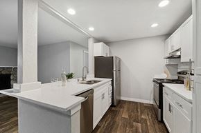 Kent apartment for rent - Model Kitchen with White Cabinets and Wood-Style Flooring at Central Flats Apartments in Kent, WA.