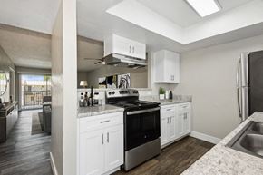Phoenix apartment for rent - a kitchen with white cabinets and a black stove top oven at Villages at Metro Center, Arizona, 85051