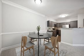 Herndon townhouse for rent - Model Dining Room with Carpet and View of Kitchen at Dulles Green Apartments located in Herndon, VA.