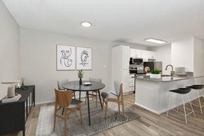 Tampa apartment for rent - Model Dining Room with Wood-Style Flooring and View of Kitchen at Seven Lakes at Carrollwood Apartments in Tampa, FL.