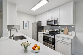 Carlsbad apartment for rent - A modern kitchen with white cabinets and appliances.