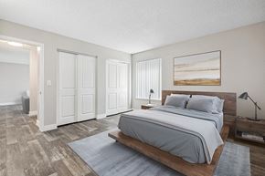 Avondale apartment for rent - Three-Bedroom Affordable Apartments in Avondale, AZ - The Peaks on 4th - A Bedroom With A Platform Bed, Matching Nightstands, Vertical Blinds, Double Closet Doors, And Wood Style Flooring.