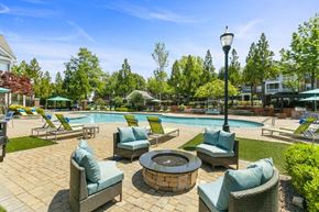 Marietta apartment for rent - Two-Bedroom Luxury Apartments in Marietta, GA - Parkside at Town Center - Resort Style Pool Courtyard With Lounge Chairs, Shaded Seating, Fire Pit Gathering Area, And Landscaped Surroundings.