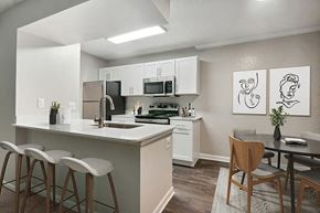 Charlotte apartment for rent - Model Dining Room and Kitchen Area with Wood-Style Flooring at Arbor Village Apartments in Charlotte, NC.