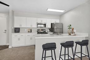 Phoenix apartment for rent - Model Kitchen with White Cabinets and Wood-Style Flooring at Crystal Creek Apartments in Phoenix, AZ.