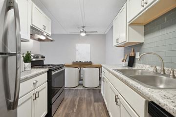 Burnsville apartment for rent - Model Kitchen with White Cabinets and Wood-Style Flooring at Parkvue Flats Apartments in Burnsville, MN.