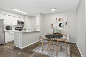 Tampa apartment for rent - Model Dining Room and Kitchen Area with Wood-Style Flooring at Grand Pavilion Apartments in Tampa, FL.