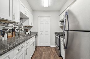 Peachtree Corners apartment for rent - Model Kitchen with White Cabinets and Wood-Style Flooring at Lakeside Retreat Apartments located in Peachtree Corners, GA.