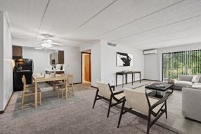 Burnsville apartment for rent - Two-Bedroom Affordable Apartments in Burnsville, MN - Elevate on Parkway - A Dining Area With Black Appliances, Wood Table Seating, And Ceiling Fan.
