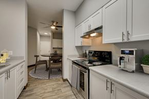 Gresham apartment for rent - Model Kitchen with White Cabinets and Wood-Style Flooring at Landings at Morrison Apartments located in Gresham, OR.