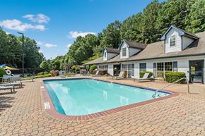 Peachtree Corners apartment for rent - Peachtree Corners, GA, Pet-Friendly Affordable Apartments - Corners At 1700 - Outdoor Swimming Pool With Brick Paver Deck, Lounge Chairs, Clubhouse Building, And Lush Greenery View.