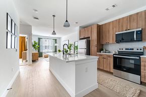 Aurora apartment for rent - A modern kitchen with wooden cabinets and a white island.