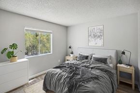 Tucson apartment for rent - One-Bedroom Apartments in Catalina Foothills, AZ - Hilands - Cozy Bedroom With Upholstered Headboard, Side Tables With Lamps, Large Window Views, And Wood-Style Flooring.
