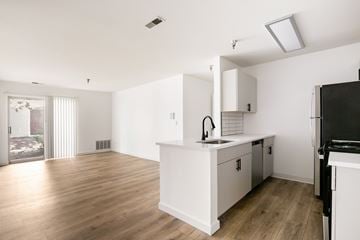 Aurora apartment for rent - A kitchen with white cabinets and a black fridge.