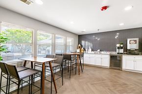 Aurora apartment for rent - Community club house seating area with a coffee machine, elevated chairs and tables.