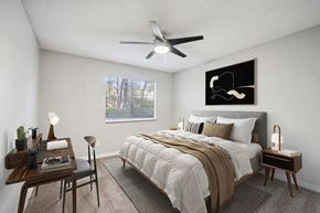 Jacksonville apartment for rent - One-Bedroom Apartments in Westside Jacksonville, FL - Westland Park - A Bedroom Features Matching Nightstands With Lamps, A Desk By The Window, Neutral Tones, And A Ceiling Fan.